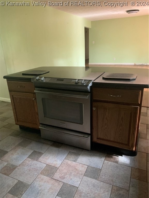 kitchen featuring stainless steel range with electric cooktop and dark brown cabinets