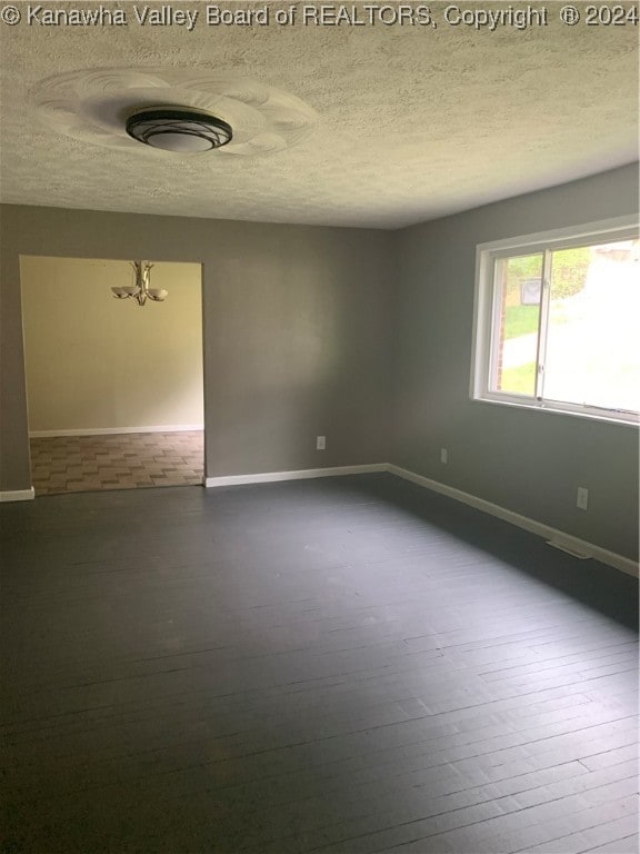 spare room featuring a textured ceiling and hardwood / wood-style flooring