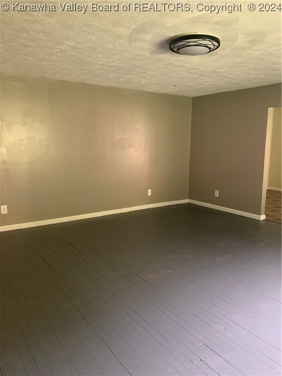 empty room with a textured ceiling and hardwood / wood-style floors