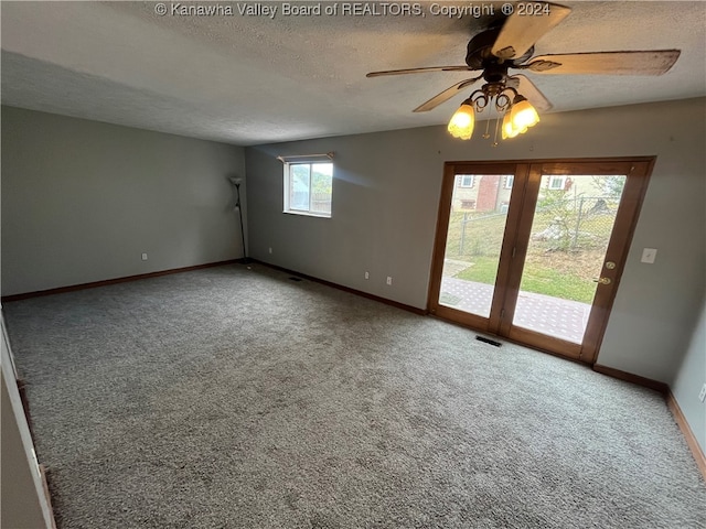 carpeted empty room with a textured ceiling and ceiling fan