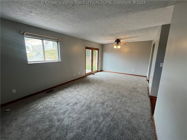 carpeted empty room featuring a textured ceiling and ceiling fan