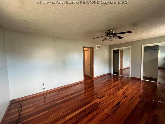 unfurnished bedroom with ceiling fan, dark hardwood / wood-style floors, and a textured ceiling