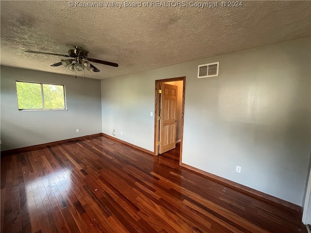 empty room with ceiling fan, a textured ceiling, and dark wood-type flooring