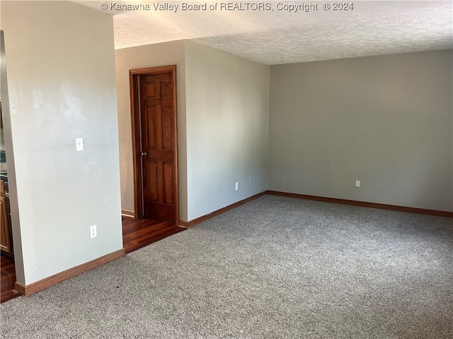 carpeted empty room with a textured ceiling