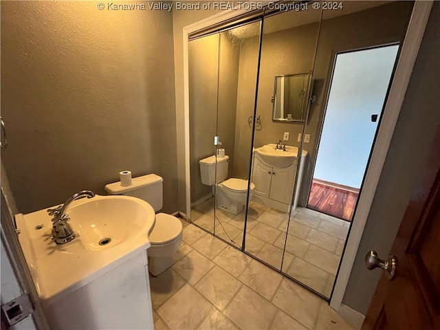 bathroom featuring vanity, toilet, and tile patterned floors