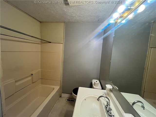 full bathroom with a textured ceiling, shower / washtub combination, vanity, and toilet