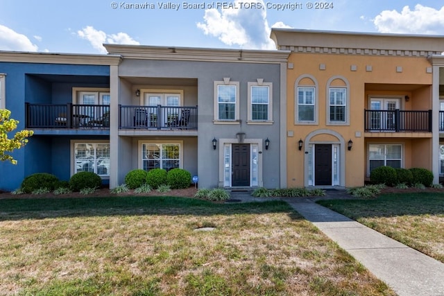 view of front of home featuring a balcony and a front lawn