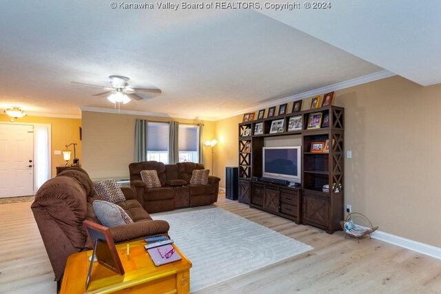 living room featuring light wood-type flooring, ceiling fan, a textured ceiling, and crown molding