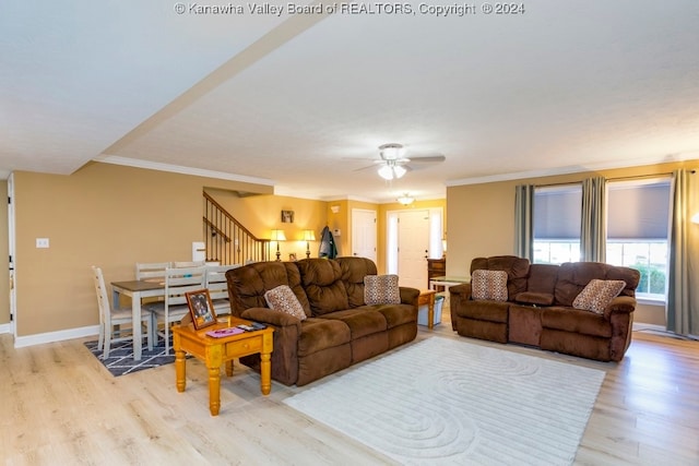 living room with ornamental molding, light hardwood / wood-style floors, and ceiling fan