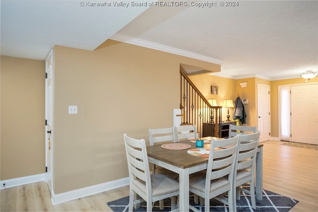 dining area with light hardwood / wood-style floors and ornamental molding