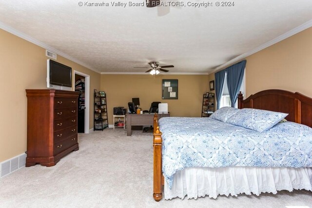 carpeted bedroom with ornamental molding, ceiling fan, and a spacious closet