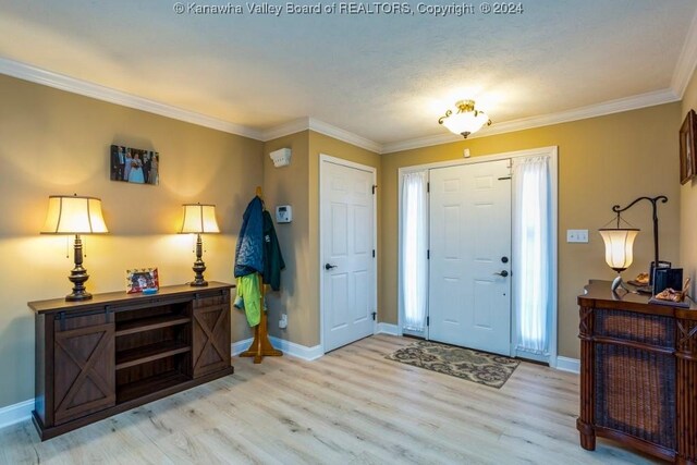 entrance foyer with light wood-type flooring, crown molding, and a textured ceiling