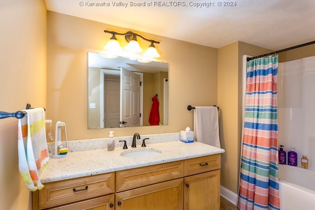 bathroom featuring shower / bath combination with curtain, vanity, and a textured ceiling