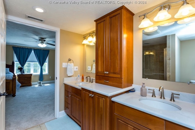 bathroom with a textured ceiling, ceiling fan with notable chandelier, vanity, and a shower with shower door