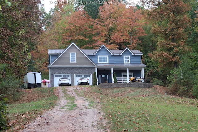 view of front of property featuring a front yard, a garage, and covered porch