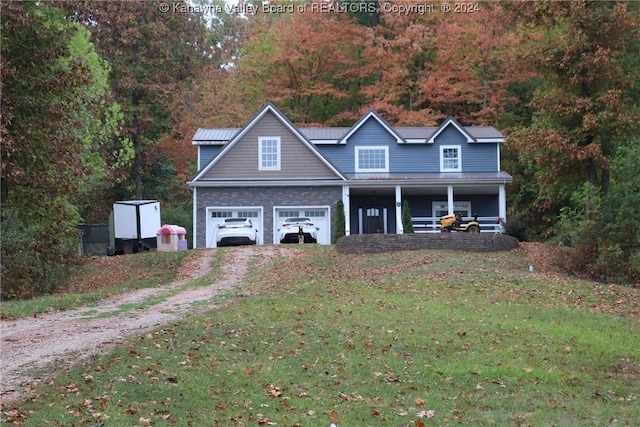 view of front of home featuring a front yard, a porch, and a garage