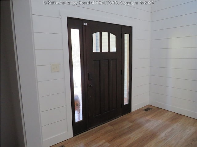 foyer with wood walls and hardwood / wood-style flooring