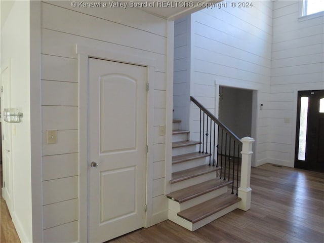 stairs featuring wood walls and hardwood / wood-style flooring