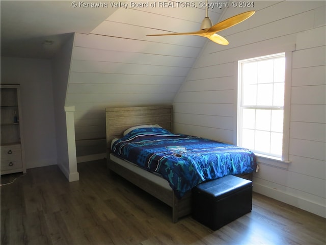 bedroom featuring vaulted ceiling, multiple windows, and dark wood-type flooring