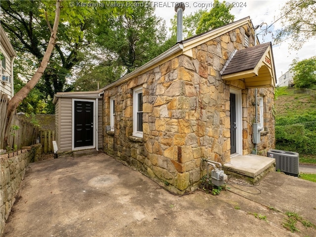 exterior space with central AC unit and a patio