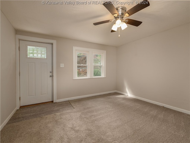 entryway with ceiling fan and carpet