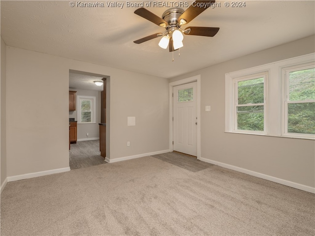 carpeted spare room with ceiling fan