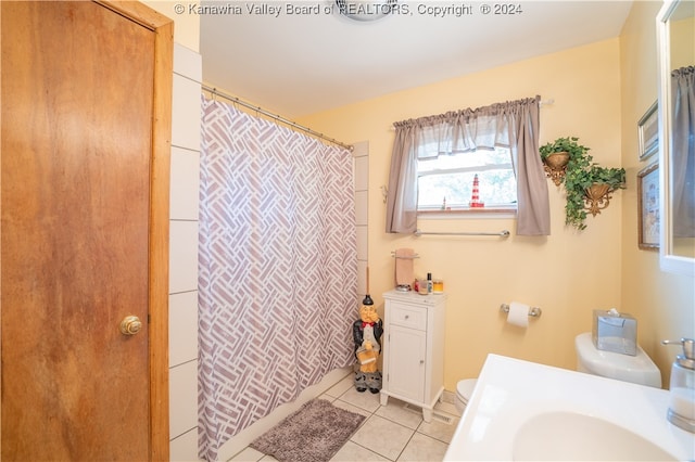 bathroom featuring sink, tile patterned flooring, toilet, and curtained shower