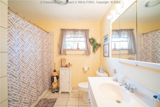 bathroom with vanity, plenty of natural light, toilet, and tile patterned floors