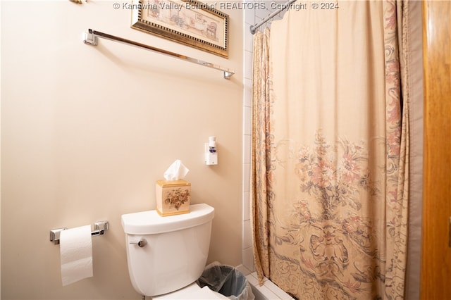 bathroom with toilet and curtained shower