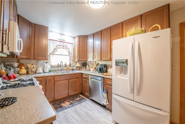 kitchen featuring light hardwood / wood-style flooring, sink, and white appliances