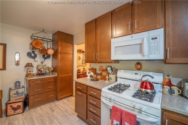 kitchen featuring white appliances and light hardwood / wood-style floors