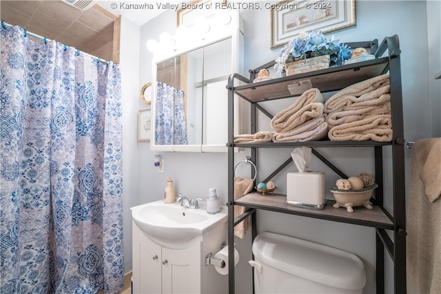 bathroom with walk in shower, vanity, and toilet