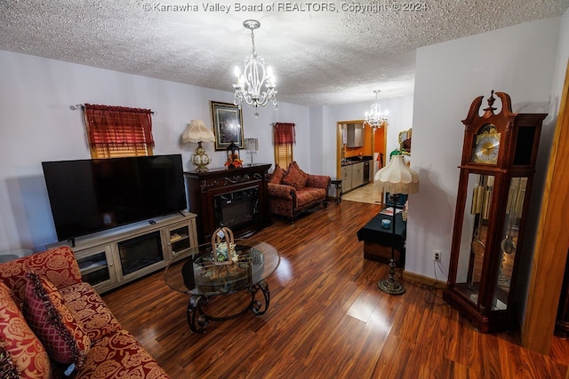 living room featuring a textured ceiling, a fireplace, dark hardwood / wood-style floors, and a chandelier