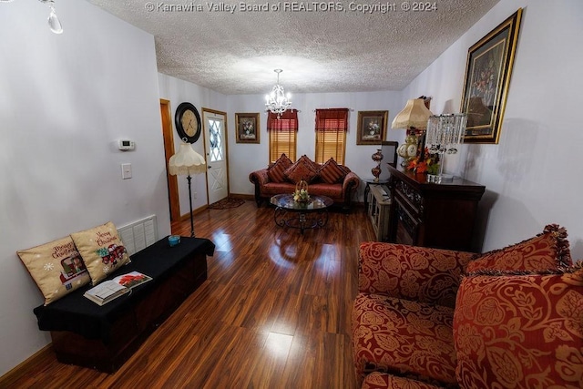 living room with hardwood / wood-style flooring, an inviting chandelier, and a textured ceiling