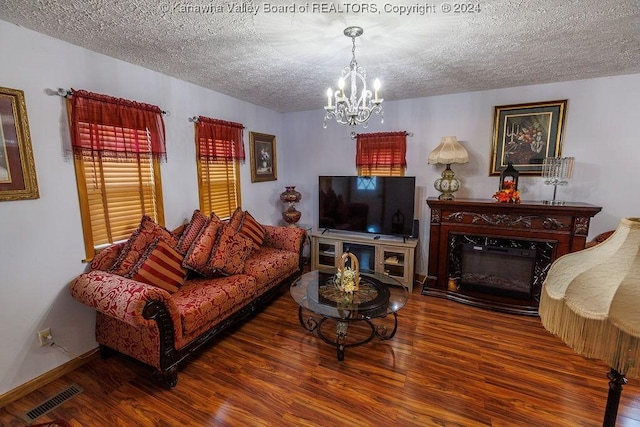 living room featuring hardwood / wood-style floors, a textured ceiling, and a notable chandelier