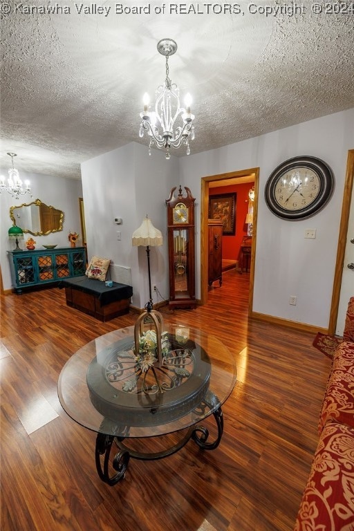 living room featuring a notable chandelier, hardwood / wood-style floors, and a textured ceiling