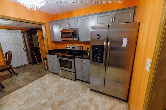 kitchen featuring a chandelier, stainless steel appliances, and gray cabinets