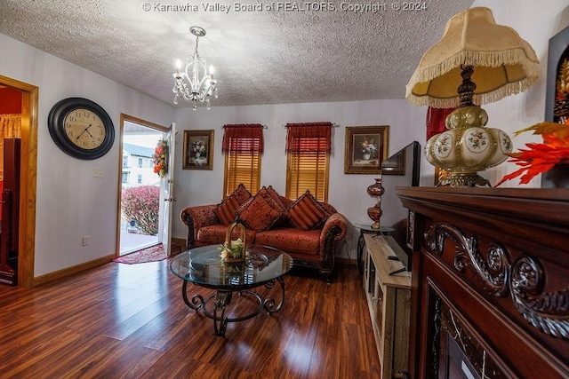 living room with dark hardwood / wood-style floors, a chandelier, and a textured ceiling