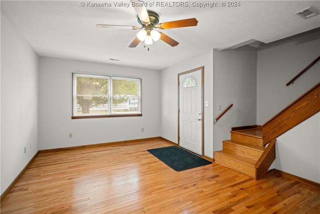 entrance foyer featuring ceiling fan, a textured ceiling, and light hardwood / wood-style flooring