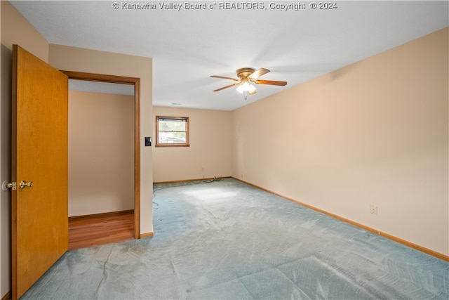 spare room featuring light carpet and ceiling fan