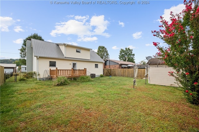 rear view of property featuring a deck, a yard, and central air condition unit