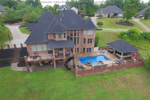 rear view of house with a gazebo, a yard, a patio, and a fenced in pool