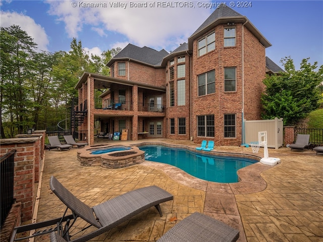 view of swimming pool featuring a patio area and an in ground hot tub