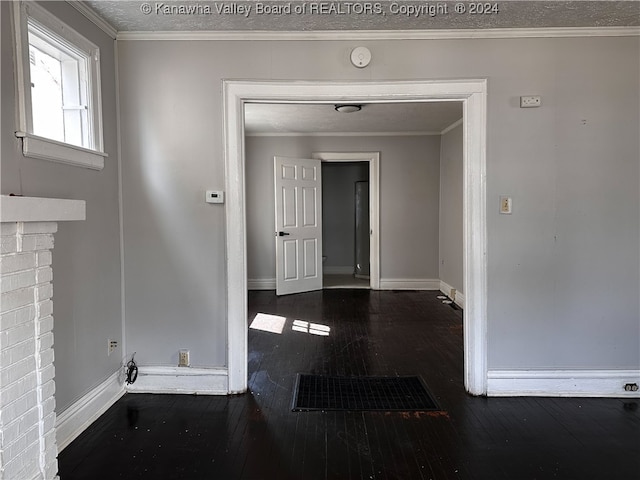 corridor featuring a textured ceiling, dark hardwood / wood-style floors, and crown molding