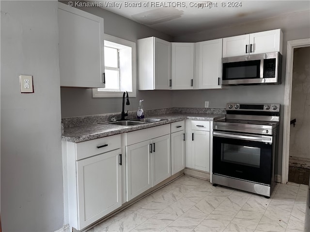 kitchen featuring appliances with stainless steel finishes, sink, and white cabinets