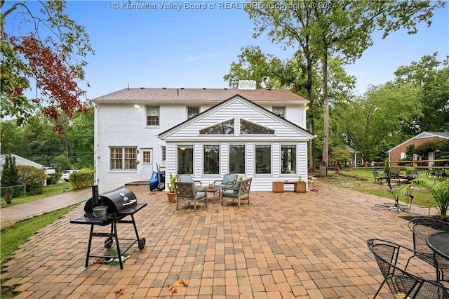 back of property featuring an outdoor living space and a patio area