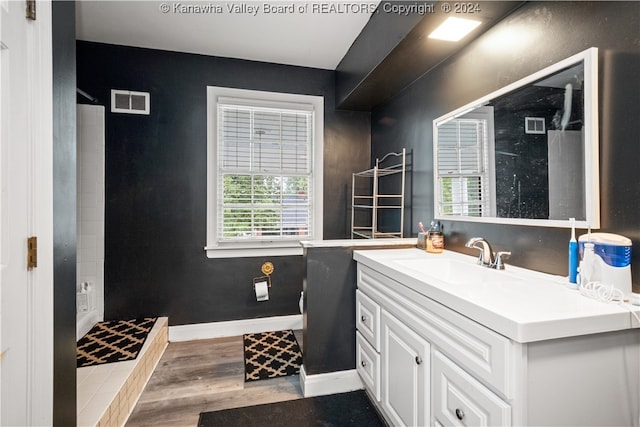 bathroom with a shower, hardwood / wood-style flooring, and a wealth of natural light