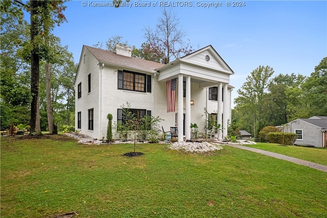 greek revival house featuring a front yard