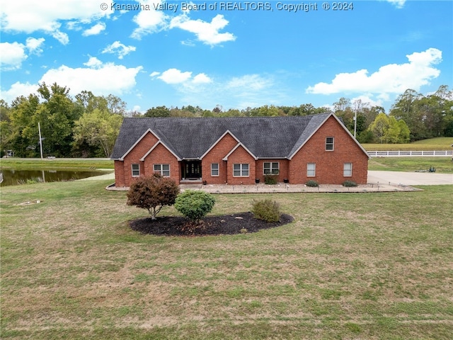 view of front of property with a front lawn and a water view