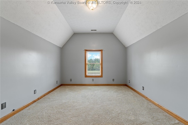 bonus room with carpet floors, a textured ceiling, and lofted ceiling